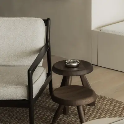 Houten bijzettafels op jute tapijt naast een fauteuil, Appartement in Nieuwpoort, interieur Laura Calleeuw