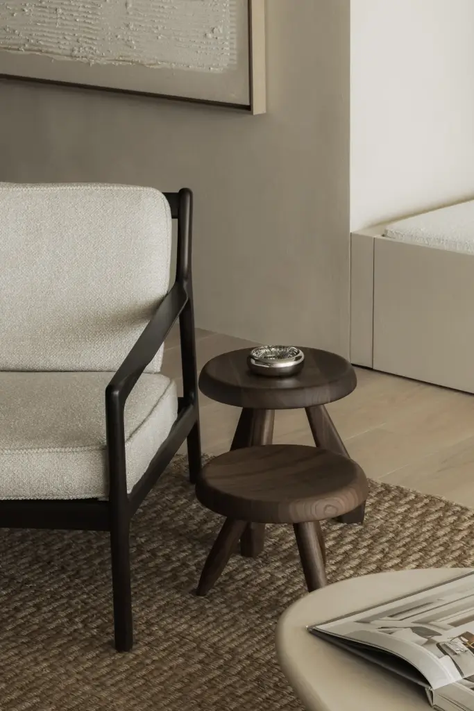 Houten bijzettafels op jute tapijt naast een fauteuil, Appartement in Nieuwpoort, interieur Laura Calleeuw