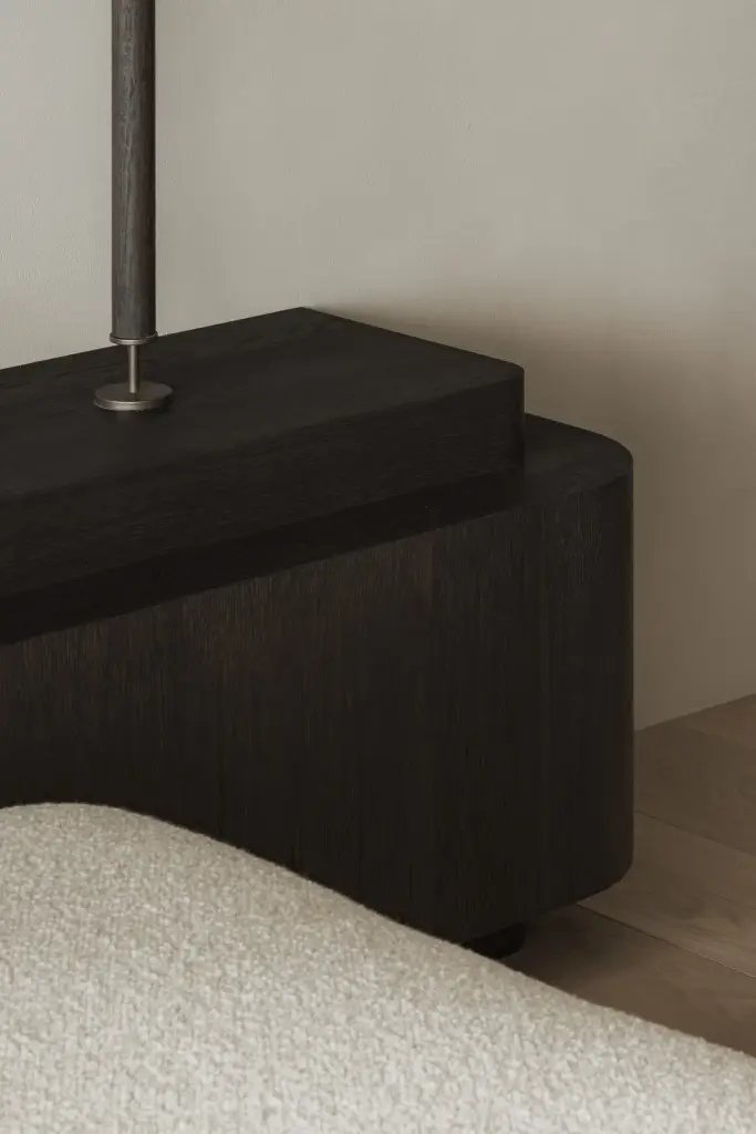 Detail van een donkere houten kast naast een bouclé sofa, Appartement in Nieuwpoort, interieur Laura Calleeuw