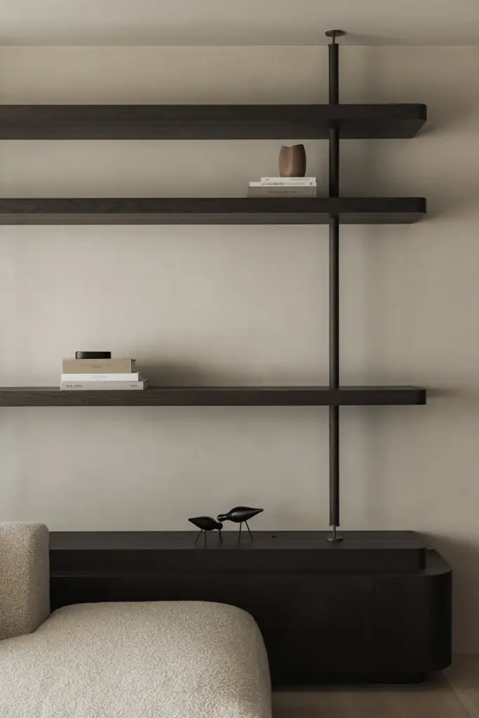Lage sofa onder een rek met boeken, Appartement in Nieuwpoort, interieur Laura Calleeuw