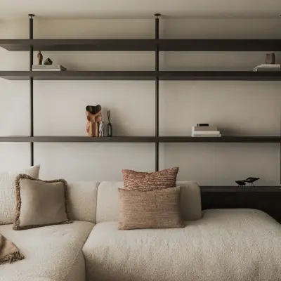 Open rekken in zwart staal en hout boven een sofa met plaid en kussens, Appartement in Nieuwpoort, interieur Laura Calleeuw