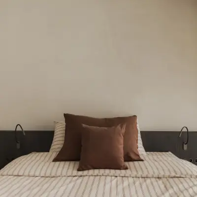 Bed met donker houten hoofdbord, leeslampjes en gordijn, Appartement in Nieuwpoort, interieur Laura Calleeuw