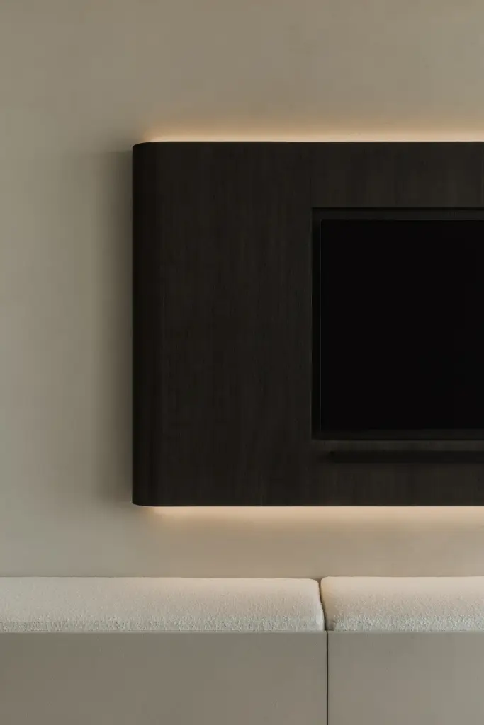 Detail van het televisiepaneel met indirecte verlichting boven de zitbank, Appartement in Nieuwpoort, interieur Laura Calleeuw