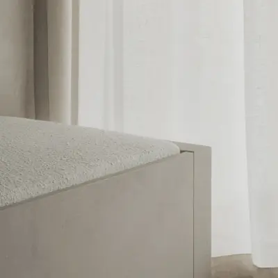 Hoek van de lage zitbank naast een raam met vitrage, Appartement in Nieuwpoort, interieur Laura Calleeuw
