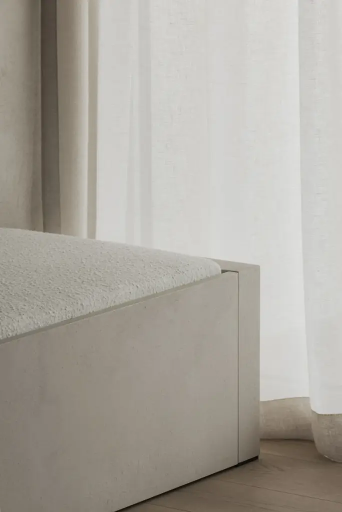Hoek van de lage zitbank naast een raam met vitrage, Appartement in Nieuwpoort, interieur Laura Calleeuw