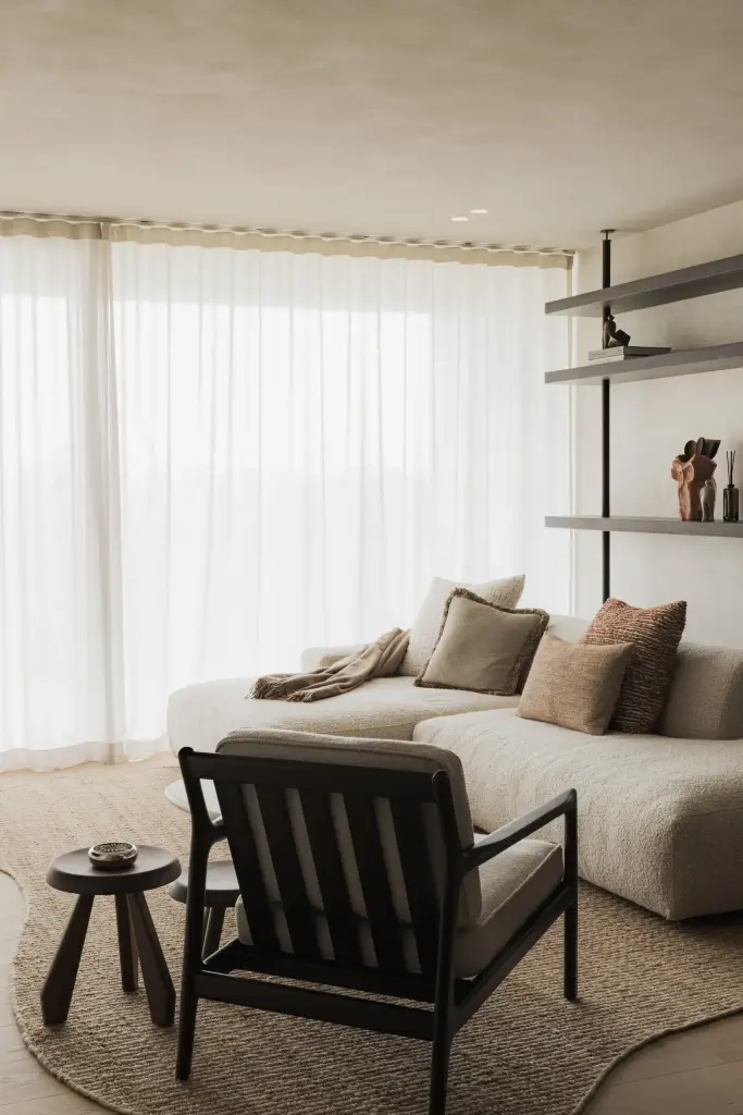 Sofa en fauteuil in de zithoek voor open rekken en vitrage, Appartement in Nieuwpoort, interieur Laura Calleeuw