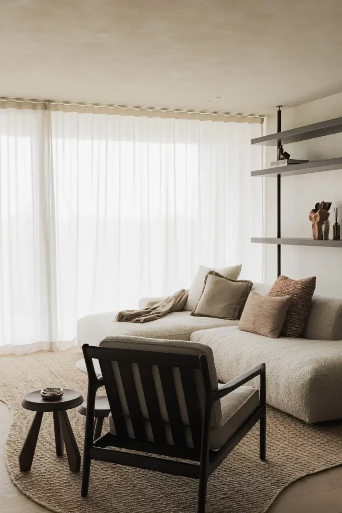 Zithoek met sofa, houten fauteuil en stalen rekken, Appartement in Nieuwpoort, interieur Laura Calleeuw