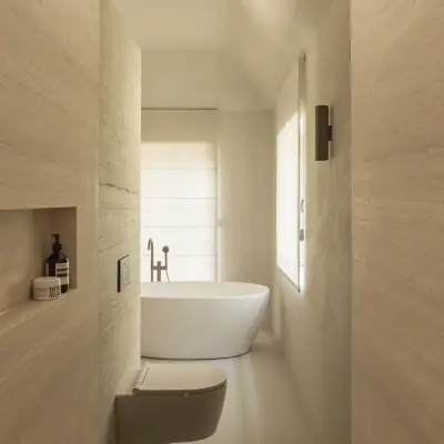 Smalle badkamer met regendouche, hangend toilet en vrijstaand bad voor het raam, Gezinsvilla in Heusden-Zolder, interieur Laura Calleeuw
