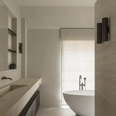 Badkamer met natuurstenen wastafel, wandlamp en vrijstaand bad, Gezinsvilla in Heusden-Zolder, interieur Laura Calleeuw