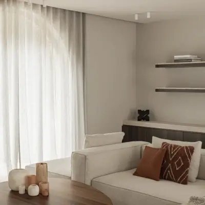 Boogvormig raam met vitrage boven de salontafel en sofa, Gezinsvilla in Heusden-Zolder, interieur Laura Calleeuw
