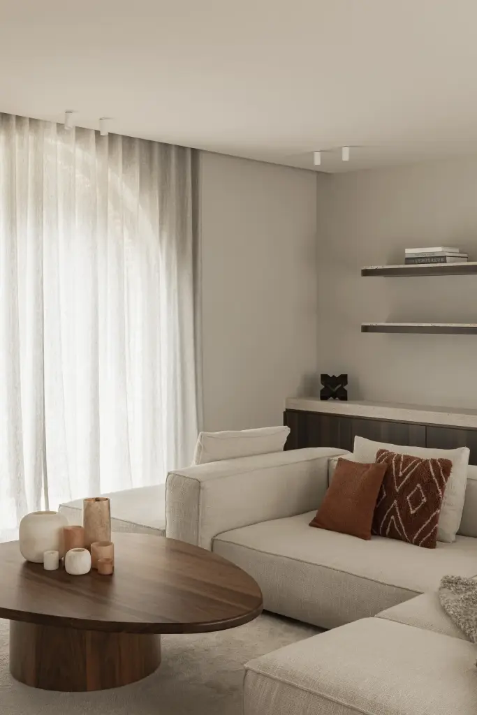Boogvormig raam met vitrage boven de salontafel en sofa, Gezinsvilla in Heusden-Zolder, interieur Laura Calleeuw