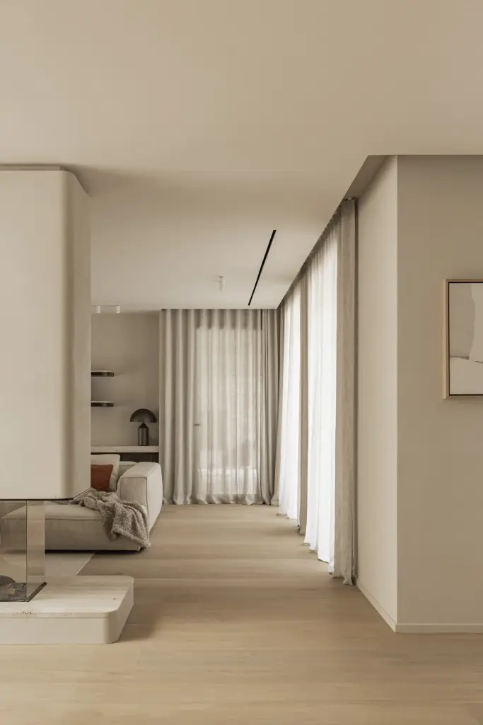 Lange doorkijk door de leefruimte met vitrage en een kunstwerk, Gezinsvilla in Heusden-Zolder, interieur Laura Calleeuw