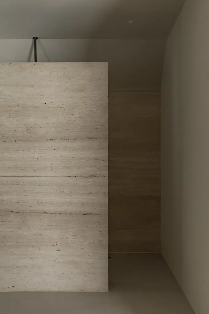 Douchewand in travertijn met ophanging aan het plafond, Gezinsvilla in Heusden-Zolder, interieur Laura Calleeuw