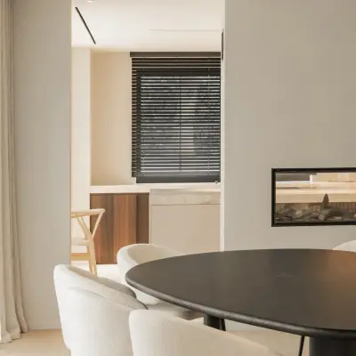 Ovale tafel met ronde witte stoelen en doorkijk naar de haard, Gezinsvilla in Heusden-Zolder, interieur Laura Calleeuw