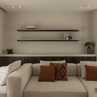 Hoeksofa met terracotta kussens voor een houten kast met verlichte wandplanken, Gezinsvilla in Heusden-Zolder, interieur Laura Calleeuw