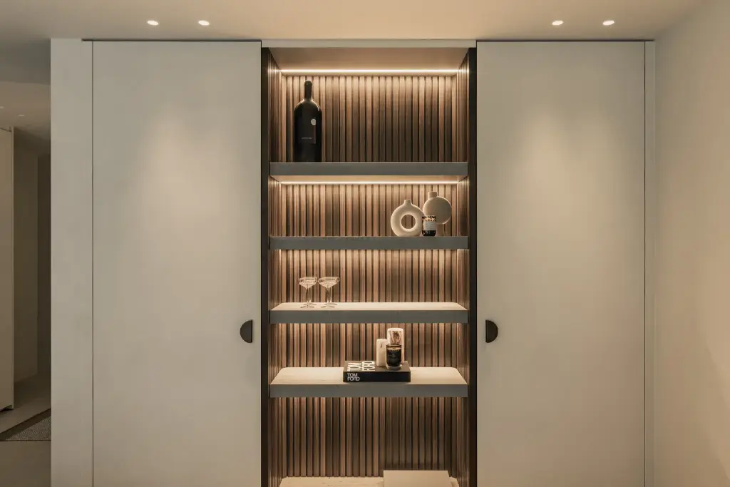 Kastenwand met open nis in houten ribbels en ronde grepen op de gepleisterde deuren, Gezinsvilla in Heusden-Zolder, interieur Laura Calleeuw