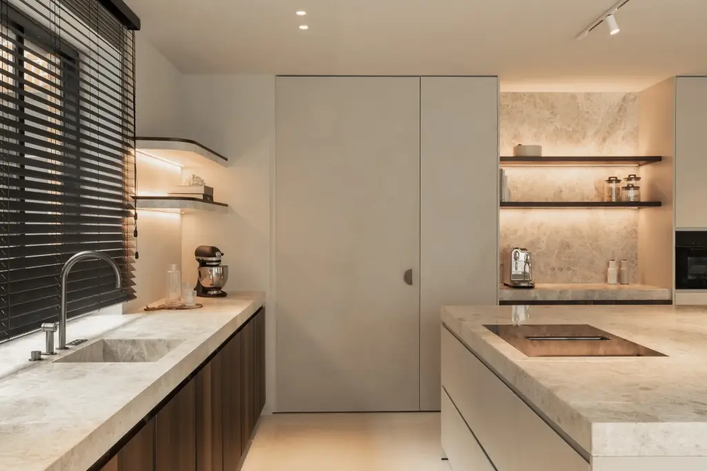 Keuken met natuurstenen werkblad en spoelbak, kookplaat en een verborgen kastdeur, Gezinsvilla in Heusden-Zolder, interieur Laura Calleeuw