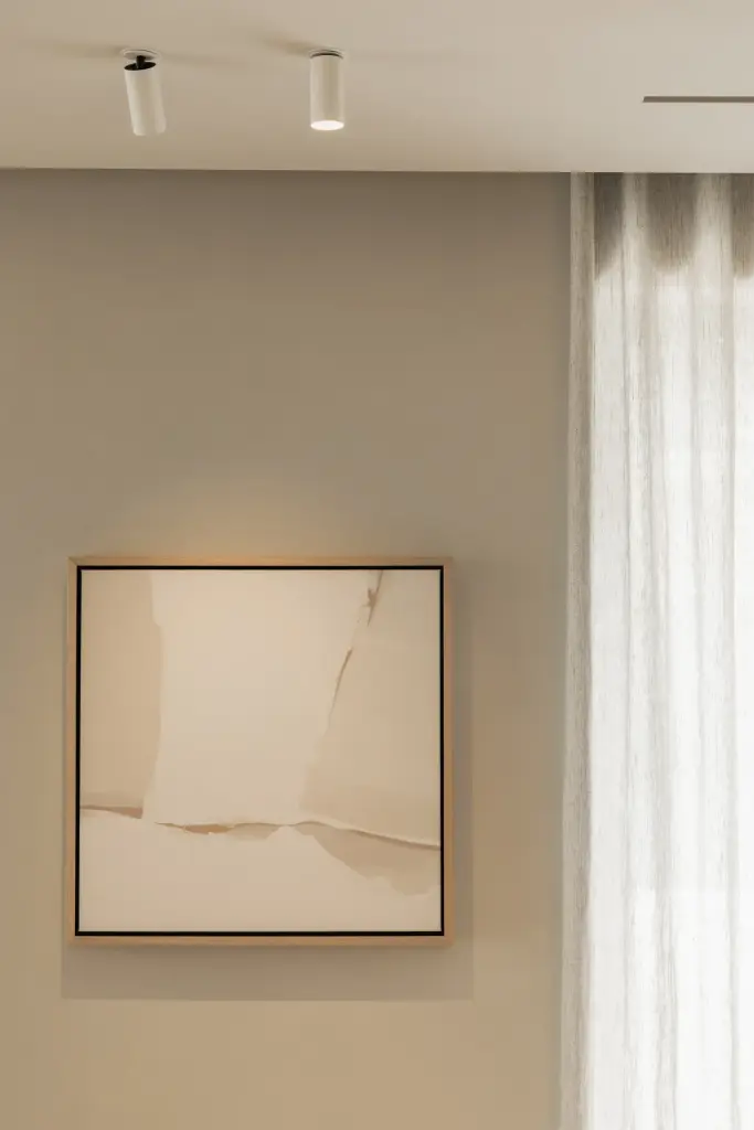 Kunstwerk aan een gepleisterde wand naast vitrage, Gezinsvilla in Heusden-Zolder, interieur Laura Calleeuw