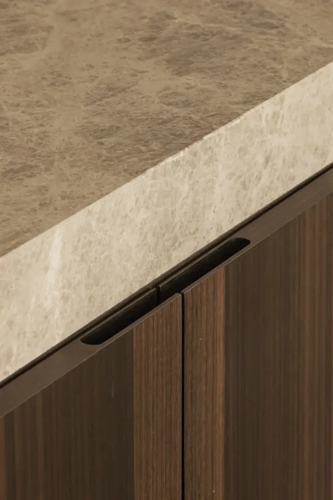 Detail van een natuurstenen werkblad boven een houten onderkast met greeplijst, Gezinsvilla in Heusden-Zolder, interieur Laura Calleeuw