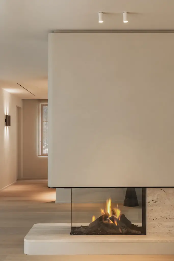 Open haard met zicht op de gang en een wandlamp, Gezinsvilla in Heusden-Zolder, interieur Laura Calleeuw