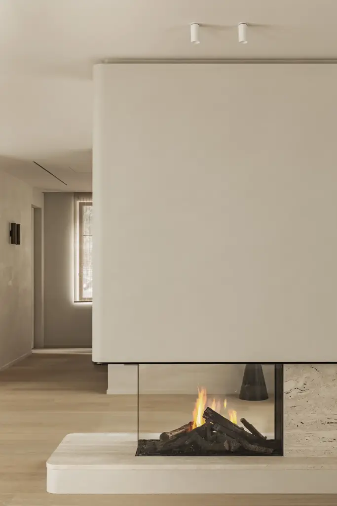 Open haard in een gepleisterd volume met doorkijk naar de leefruimte, Gezinsvilla in Heusden-Zolder, interieur Laura Calleeuw