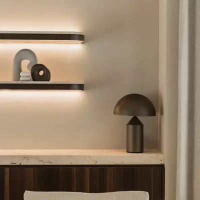 Tafellamp en planken boven een houten kast en sofa met terracotta kussen, Gezinsvilla in Heusden-Zolder, interieur Laura Calleeuw