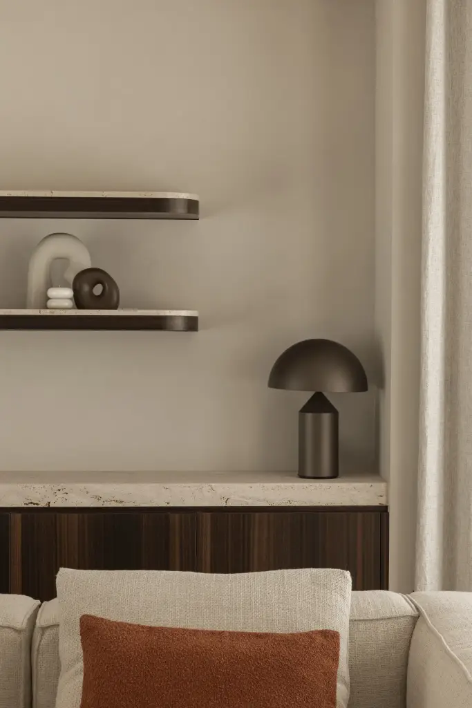 Tafellamp en planken boven een houten kast en sofa met terracotta kussen, Gezinsvilla in Heusden-Zolder, interieur Laura Calleeuw