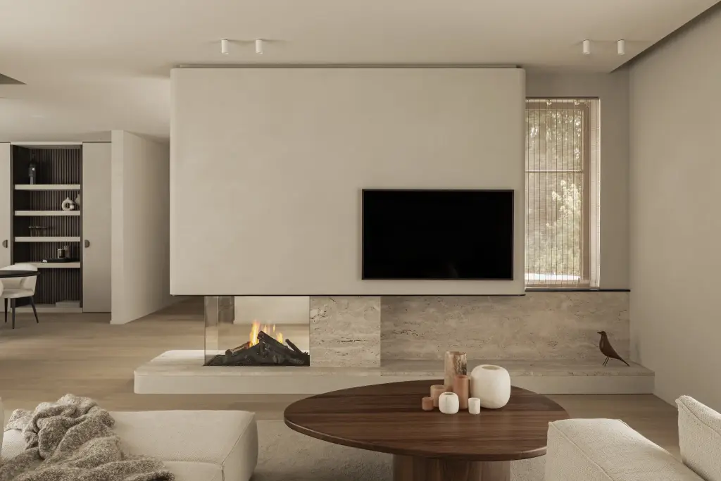 Leefruimte met televisie boven een open haard in natuursteen en een ovale houten salontafel, Gezinsvilla in Heusden-Zolder, interieur Laura Calleeuw