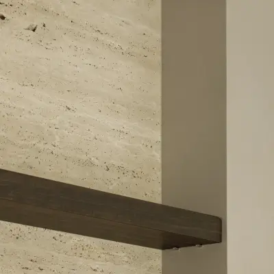 Detail van een travertijnen wand met donkere houten plank, Gezinsvilla in Heusden-Zolder, interieur Laura Calleeuw