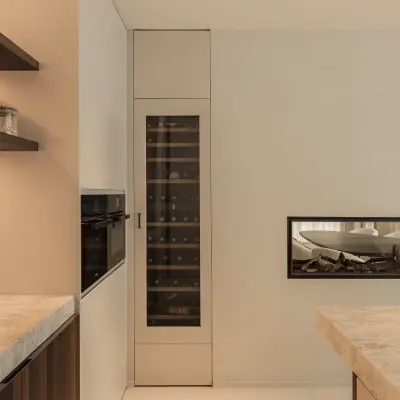Wijnklimaatkast en inbouwoven naast een lage open haard in de keuken, Gezinsvilla in Heusden-Zolder, interieur Laura Calleeuw