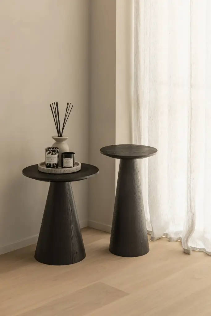 Zwarte bijzettafels met geurstokjes voor een raam met vitrage, Gezinsvilla in Heusden-Zolder, interieur Laura Calleeuw