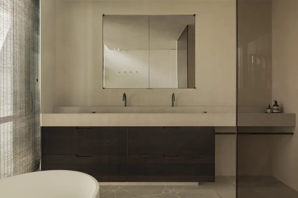 Badkamer met dubbele wastafel, spiegelkast en donkere houten onderkast, a home that invites you to slow down, interieur Laura Calleeuw