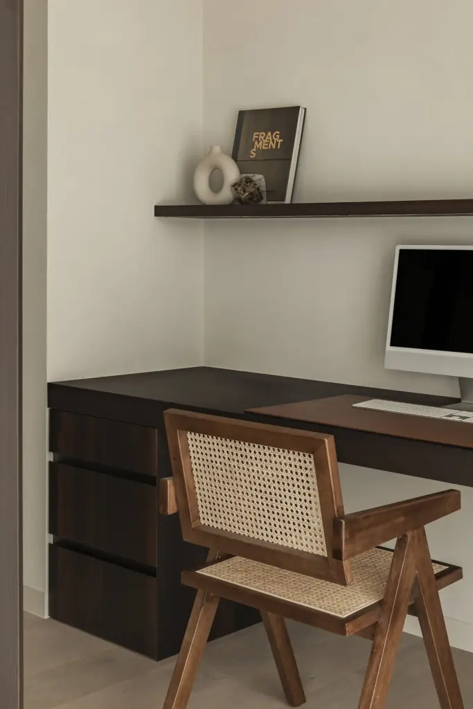 Bureau met computer en een houten stoel met rieten rug, a home that invites you to slow down, interieur Laura Calleeuw