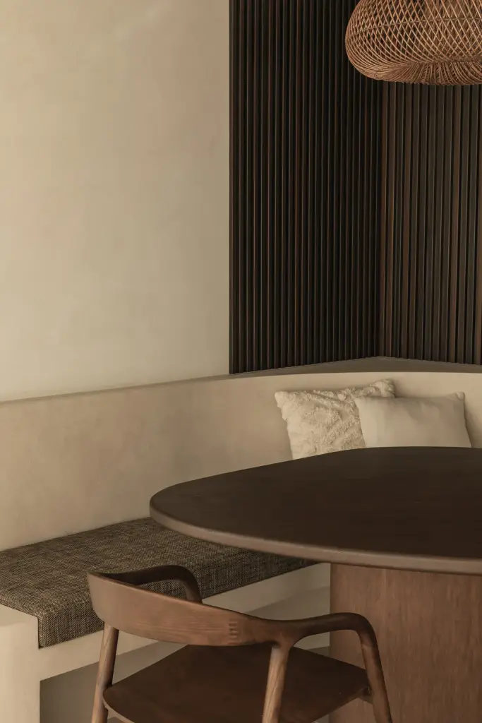 Eethoek met inbouwbank en een wijnklimaatkast onder het raam, a home that invites you to slow down, interieur Laura Calleeuw