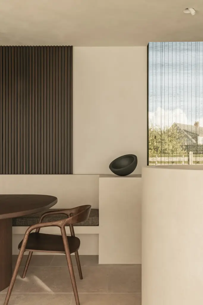 Eethoek met houten ribbelwand, raam en een zwarte schaal, a home that invites you to slow down, interieur Laura Calleeuw