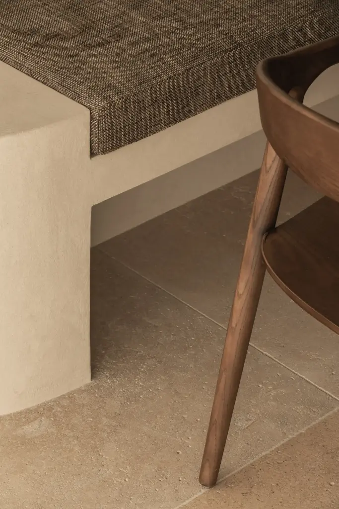 Detail van een houten eetstoel naast de gestoffeerde inbouwbank, a home that invites you to slow down, interieur Laura Calleeuw