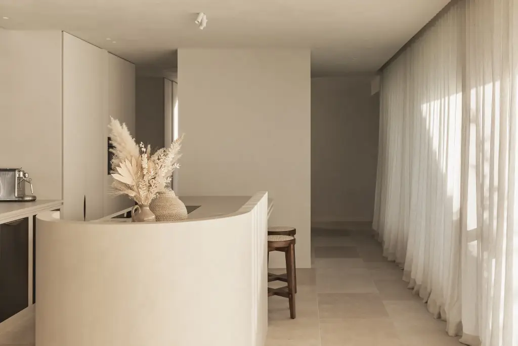 Gebogen kookeiland in kalkpleister met droogbloemen en vitrage, a home that invites you to slow down, interieur Laura Calleeuw