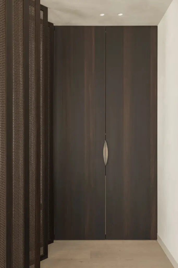 Hoge donkere houten kast met een gebogen greep, a home that invites you to slow down, interieur Laura Calleeuw