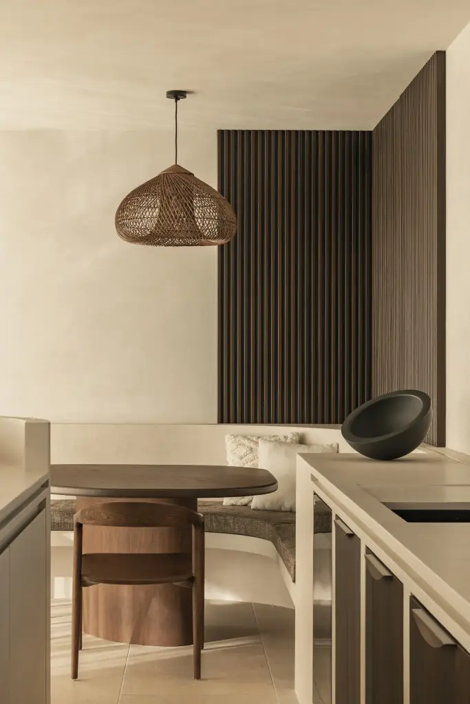 Keuken met ovale eettafel, zwarte schaal en een rotan hanglamp, a home that invites you to slow down, interieur Laura Calleeuw