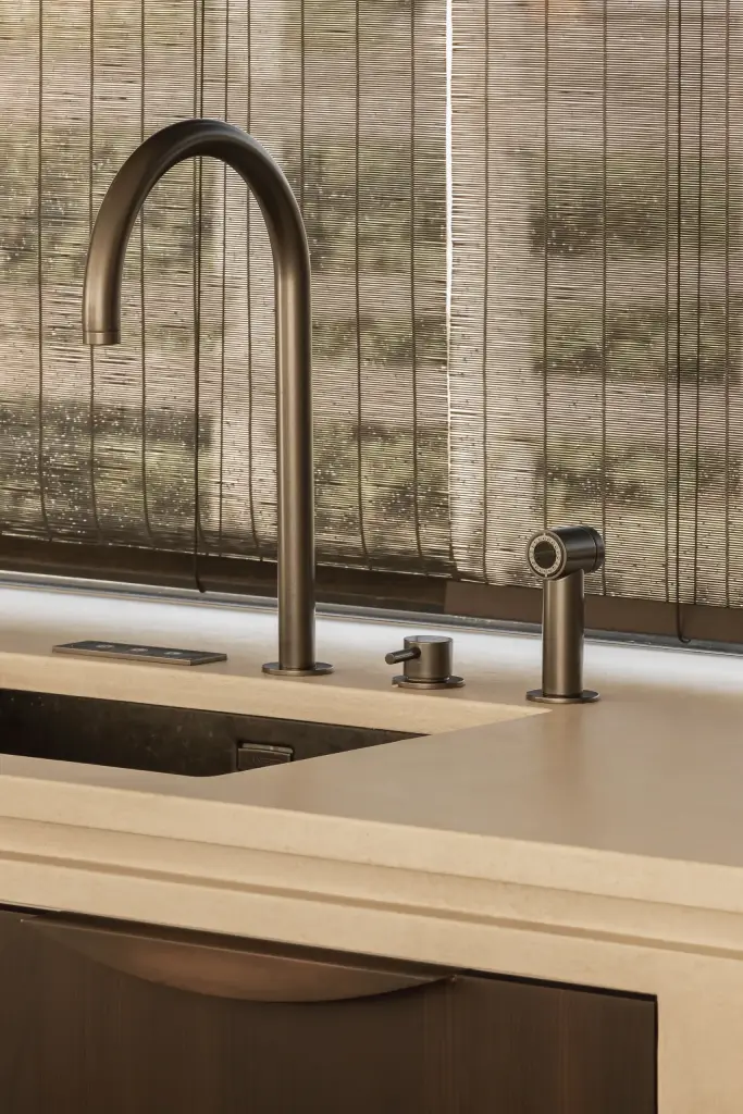 Zwarte keukenkraan met spoelbak voor een rieten zonwering, a home that invites you to slow down, interieur Laura Calleeuw