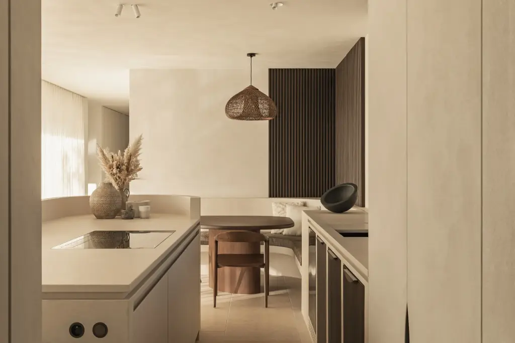 Kookeiland met inductiekookplaat, droogbloemen en een rotan hanglamp boven de eettafel, a home that invites you to slow down, interieur Laura Calleeuw