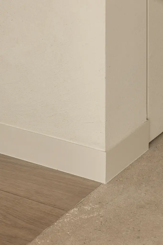 Detail van de plint in een hoek tussen natuursteen en eikenhouten vloer, a home that invites you to slow down, interieur Laura Calleeuw