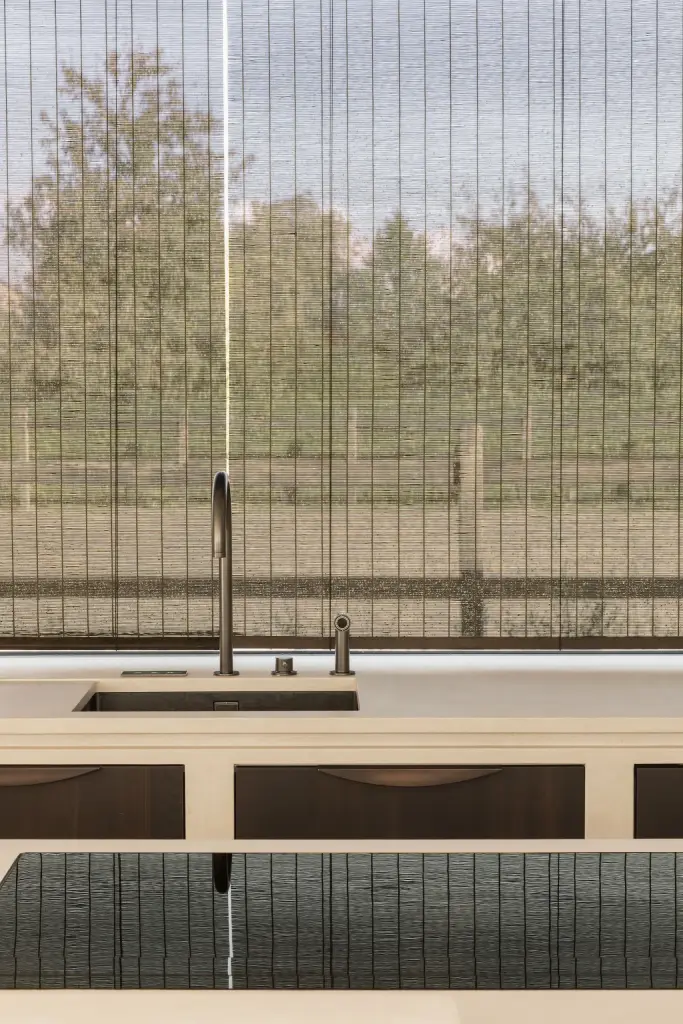 Spoelbak met kraan voor een raam met rieten zonwering, a home that invites you to slow down, interieur Laura Calleeuw