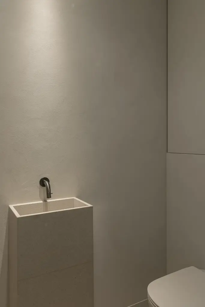 Fontein en hangtoilet in een gepleisterd toilet, a home that invites you to slow down, interieur Laura Calleeuw