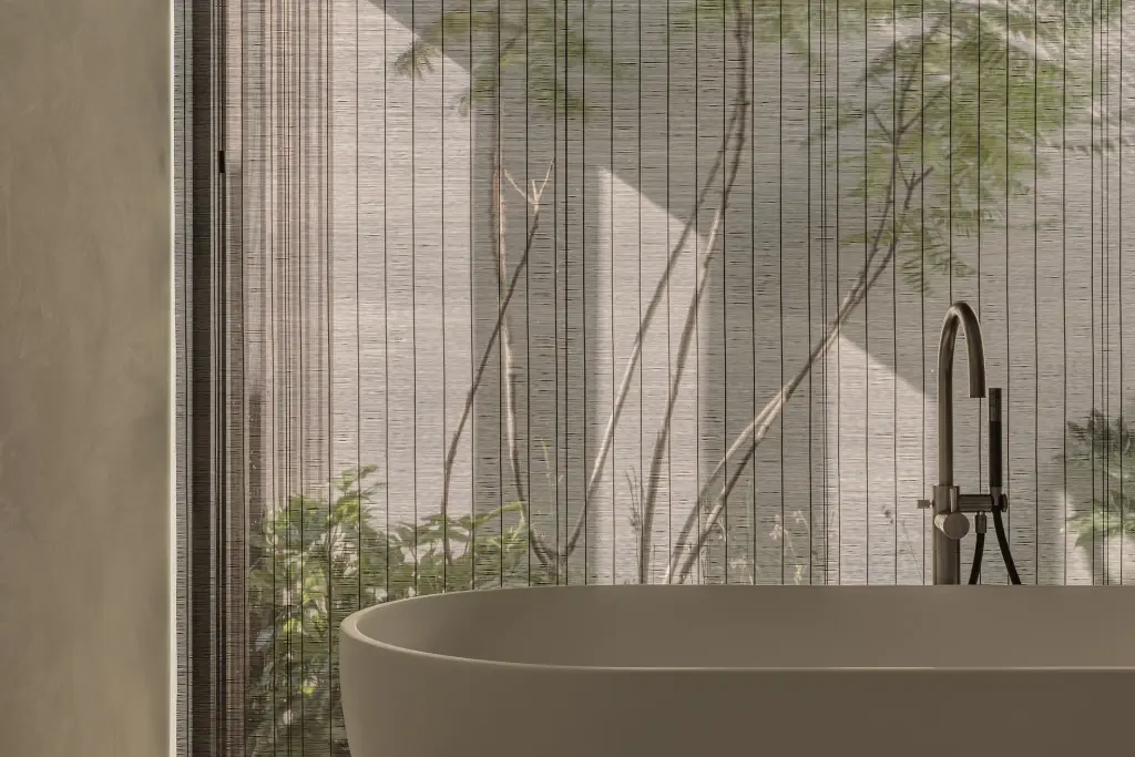 Vrijstaand bad met zwarte badkraan voor een glazen wand met patio en planten, a home that invites you to slow down, interieur Laura Calleeuw