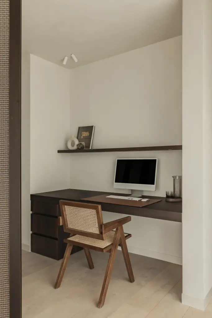Werkhoek met zwevend bureau, rieten stoel, plank en computer, a home that invites you to slow down, interieur Laura Calleeuw