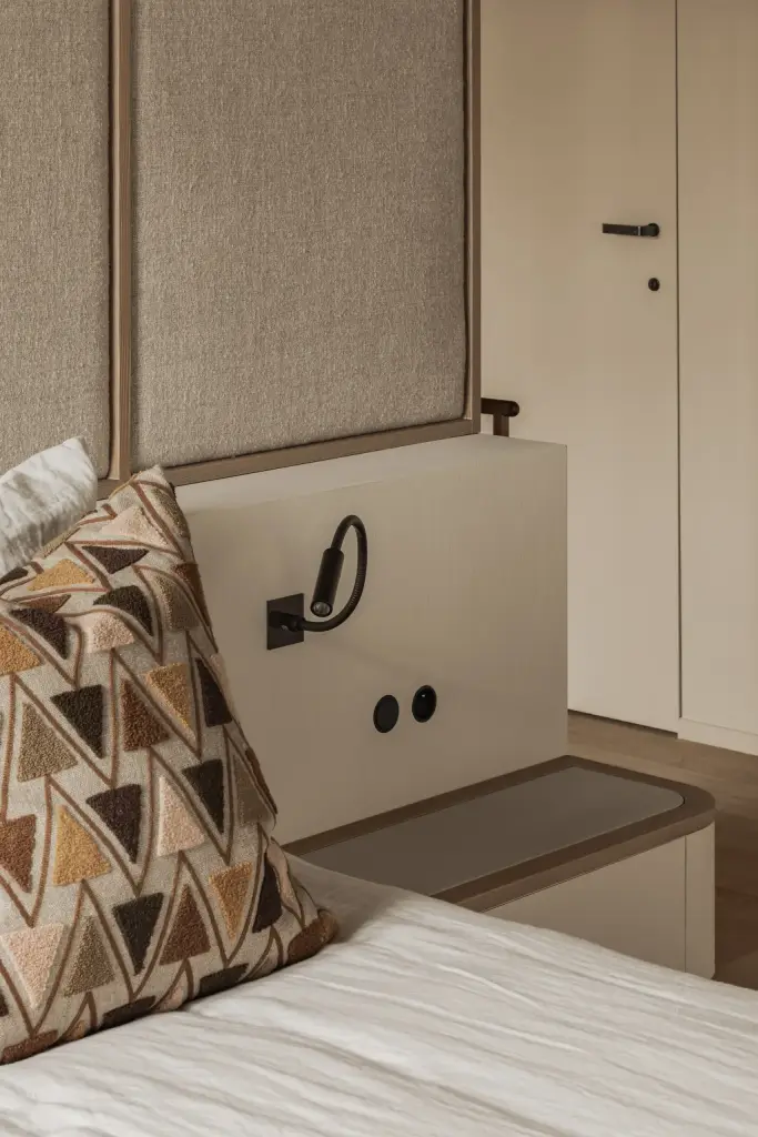 Hoek van het bed met gestoffeerd hoofdbord, leeslamp en kussen, Hoeve in Westkapelle, interieur Laura Calleeuw