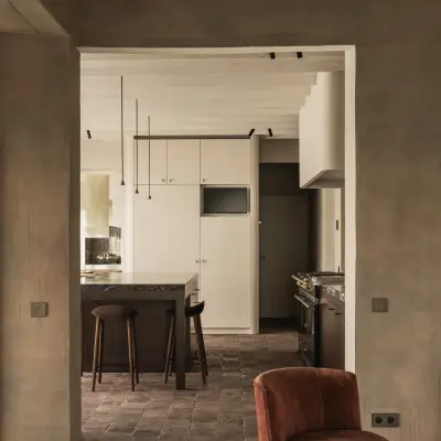 Doorkijk door de gang naar de keuken met een fauteuil op de voorgrond, Hoeve in Westkapelle, interieur Laura Calleeuw