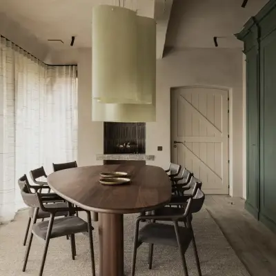 Eetkamer met lichtgroene hanglamp boven de ovale tafel en lange vitrage, Hoeve in Westkapelle, interieur Laura Calleeuw