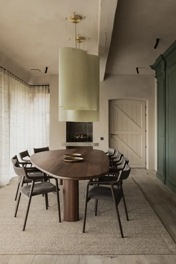 Eetkamer met lichtgroene hanglamp boven de ovale tafel en lange vitrage, Hoeve in Westkapelle, interieur Laura Calleeuw